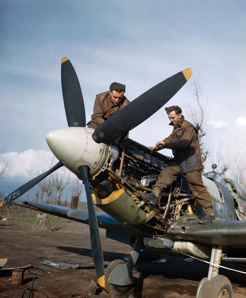 Ground crew working on an exposed aircraft engine in the open