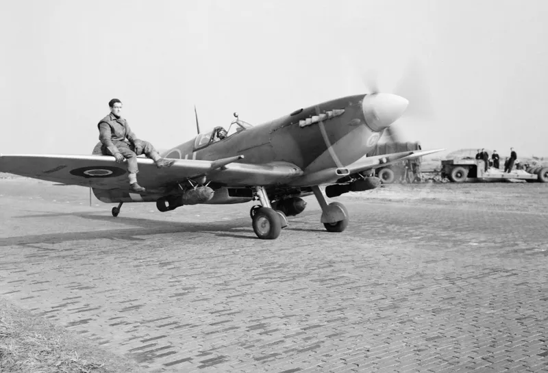 A Spitfire with bombs under its wings on an airfield