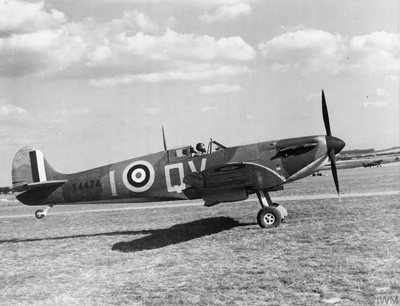 A Spitfire taking off from a grass airfield